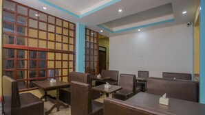 Ein Restaurant mit Sitzecken und Tischen, Holzboden und einer blau-weißen Farbgestaltung.