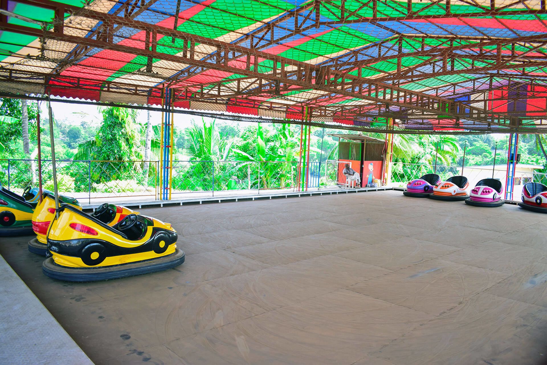 A carrousel area with bumper cars and a covered structure.