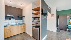 Eine kompakte Küche mit Holzausstattung, einer Mikrowelle und einem eingebauten Backofen.