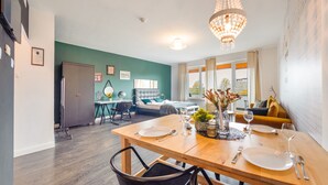 Ein modernes Wohnzimmer mit Essbereich, einem Bett und Blick ins Freie.