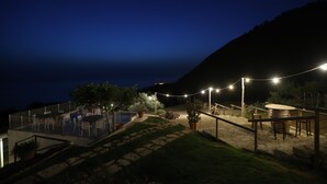 Ein Außenbereich mit Terrasse, Pool, Sitzgelegenheiten und Lichterketten.