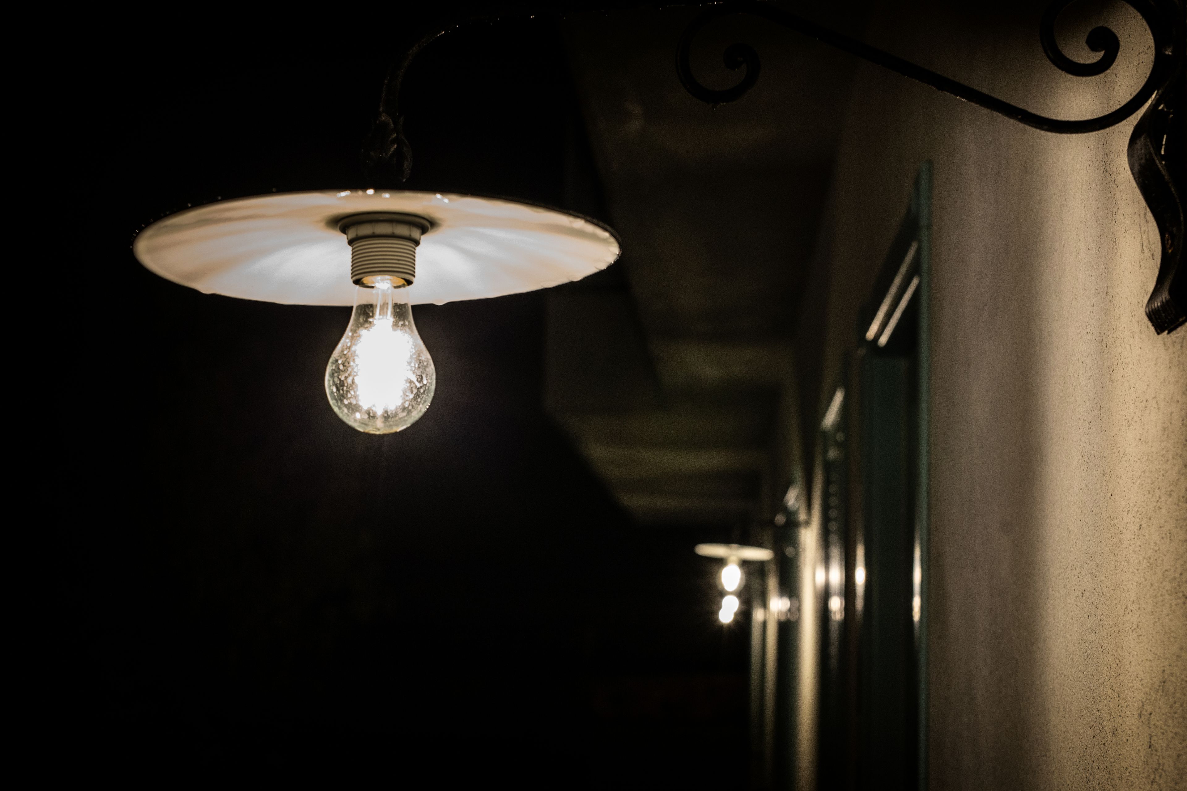 Una lampadina a sospensione con paralume in vetro satinato.