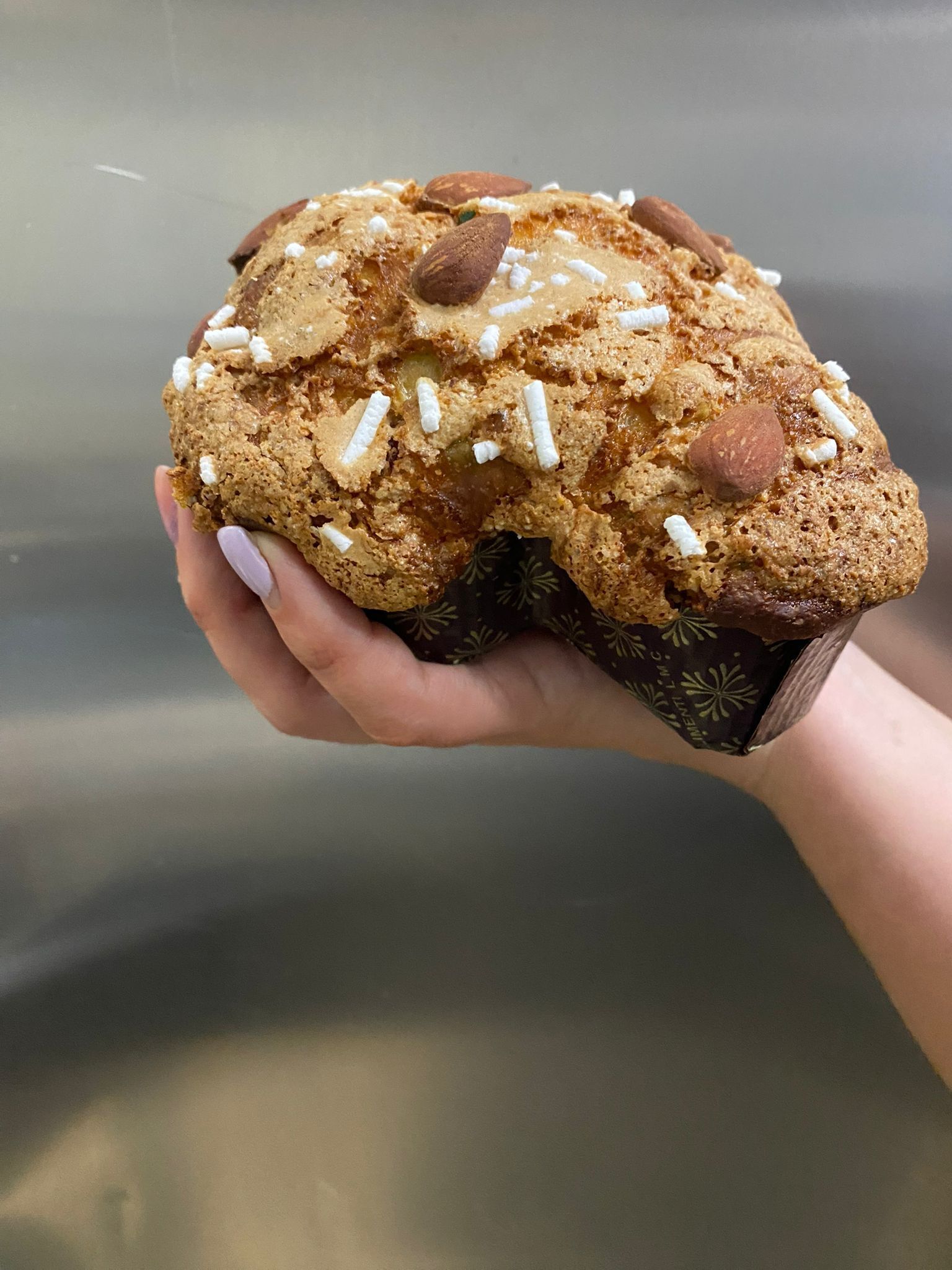 A muffin with almonds and white sprinkles.