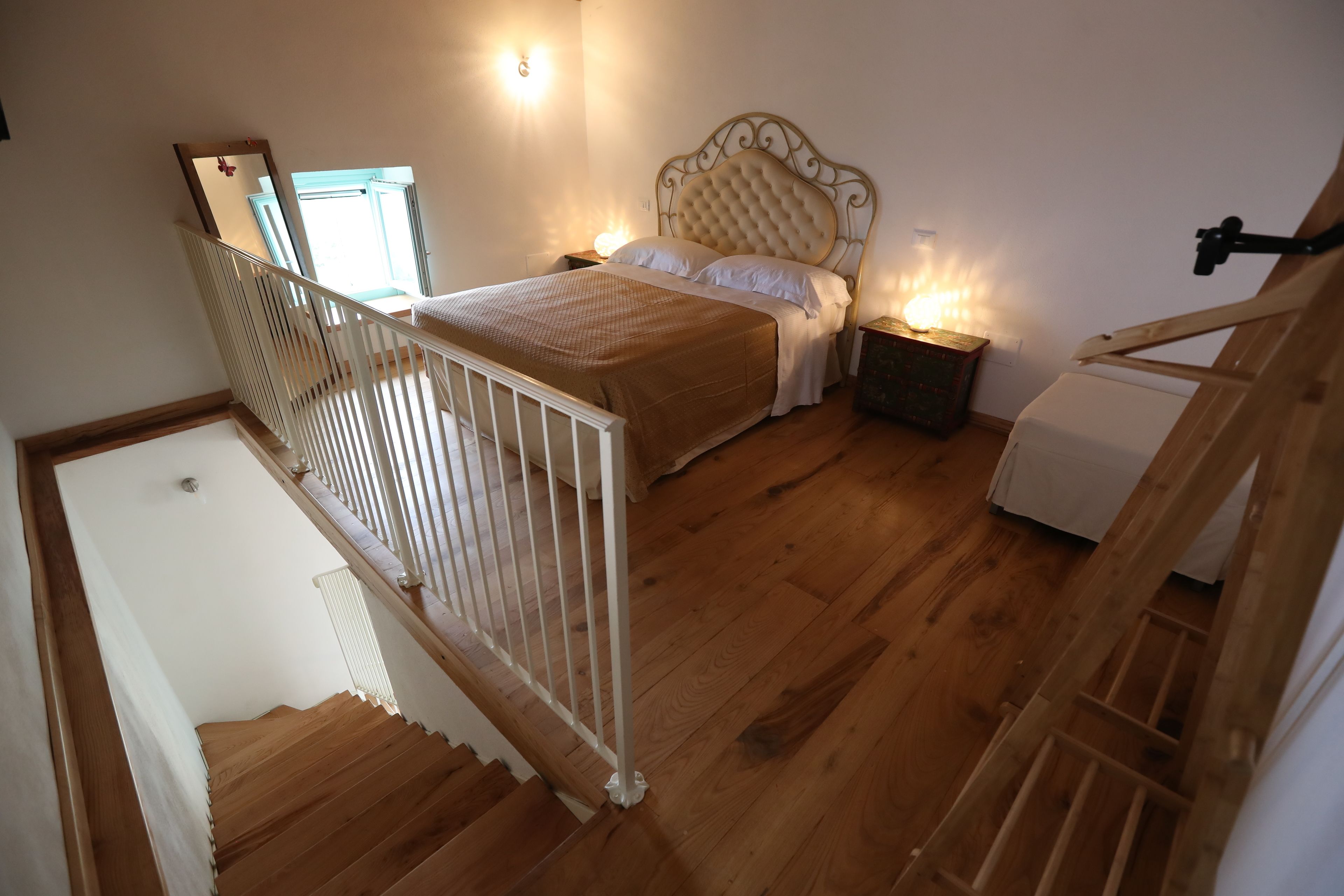 Un dormitorio con cama, mesitas de noche y una escalera de madera.