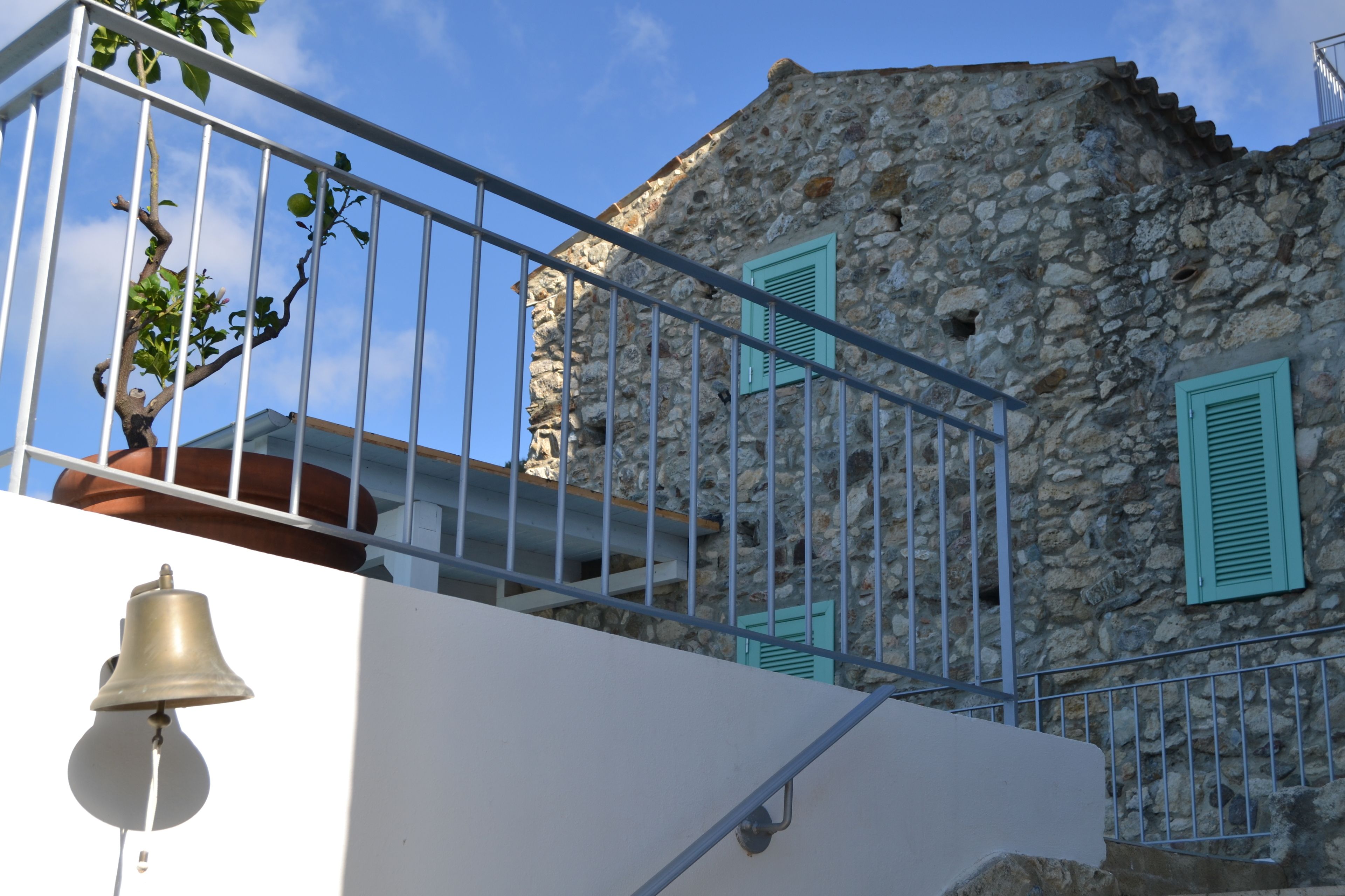 Un edificio de piedra con balcón y barandilla de metal.