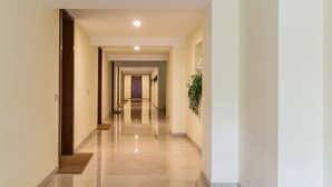A long, well-lit hallway with a polished floor, leading to multiple doors. - Lake Panorama (Como)