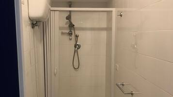 A small bathroom with a toilet, sink, and shower.
