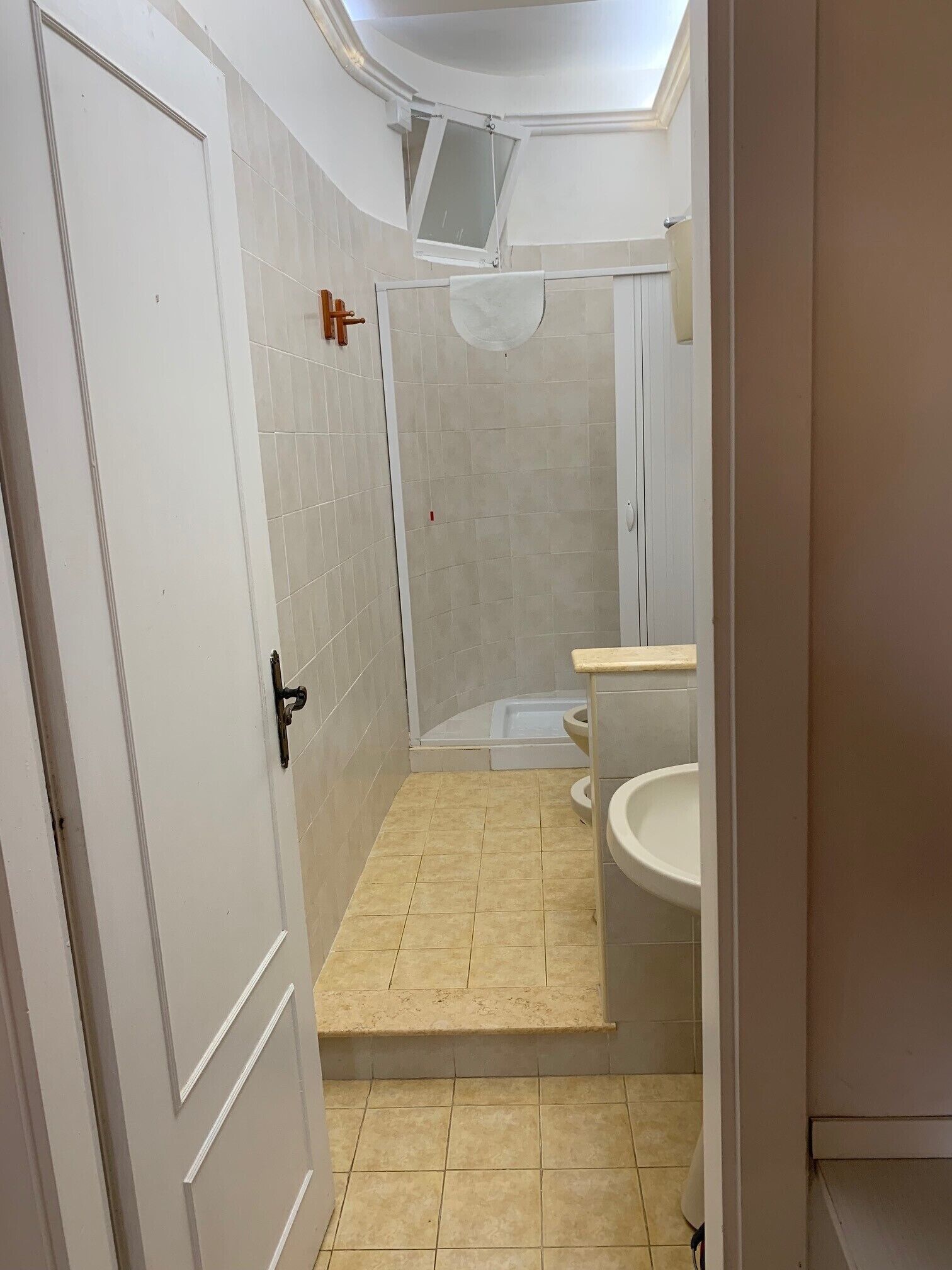 A bathroom with a shower, toilet, and sink.