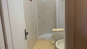 A bathroom with a shower, toilet, and sink.