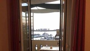 Une pièce dotée d’une porte-fenêtre coulissante donnant sur un balcon équipé d’une table et de chaises.
