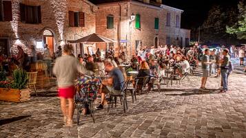 An outdoor dining area with stone paving and brick buildings in the background.