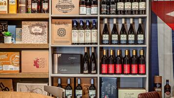 Una tienda de vinos y licores con estantes llenos de botellas y cajas de diversos tipos.