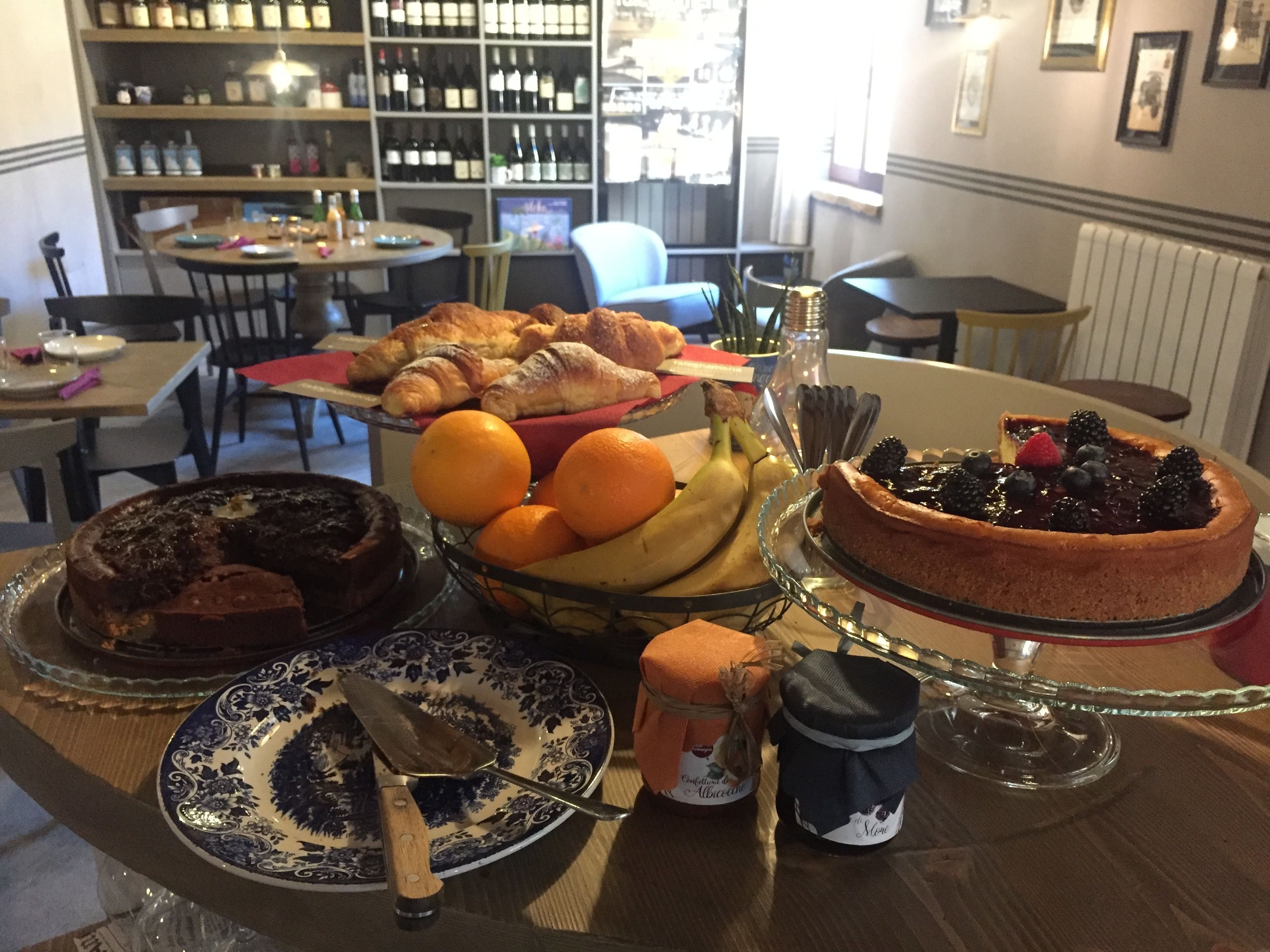 Een eettafel met gebak, fruit en een taart.