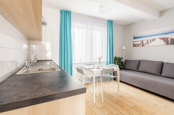Habitación cuádruple, cocineta | Espacio para trabajar con laptop y cortinas blackout 