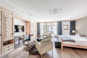 Ein modernes Hotelzimmer mit einem hölzernen Bett, einem Schreibtisch, einem Stuhl und einem Sofa.