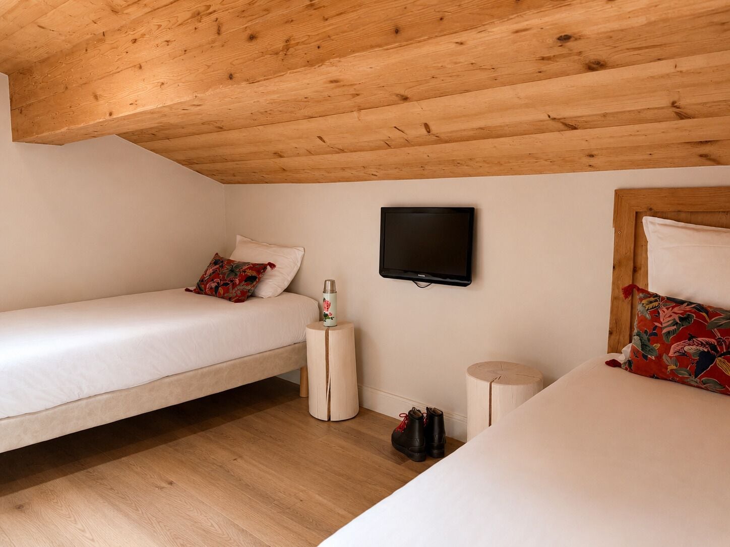 Een kamer met twee bedden, een televisie en een klein tafeltje.