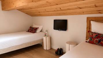 A room with two beds, a television, and a small table.