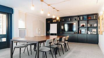 A conference room with a long table, six chairs, and a whiteboard.