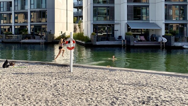Un edificio moderno con varios balcones y una zona de piscina.