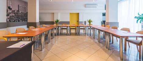 A conference room with a long table, chairs, and a projector.