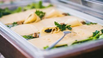 A buffet with various pasta dishes, garnished with parsley and walnuts.