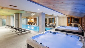 Un área de spa con piscina, sillas de descanso e hidromasajes.