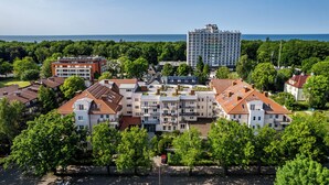 A residential area with a mix of apartment buildings and houses, featuring a variety of roof styles and balconies. - Apartamenty Sun & Snow Olymp (Kolobrzeg)