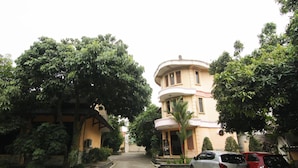 A two-story building with a curved facade, a central entrance with a canopy, and a paved driveway. - Grand Ciwareng Inn (Purwakarta)