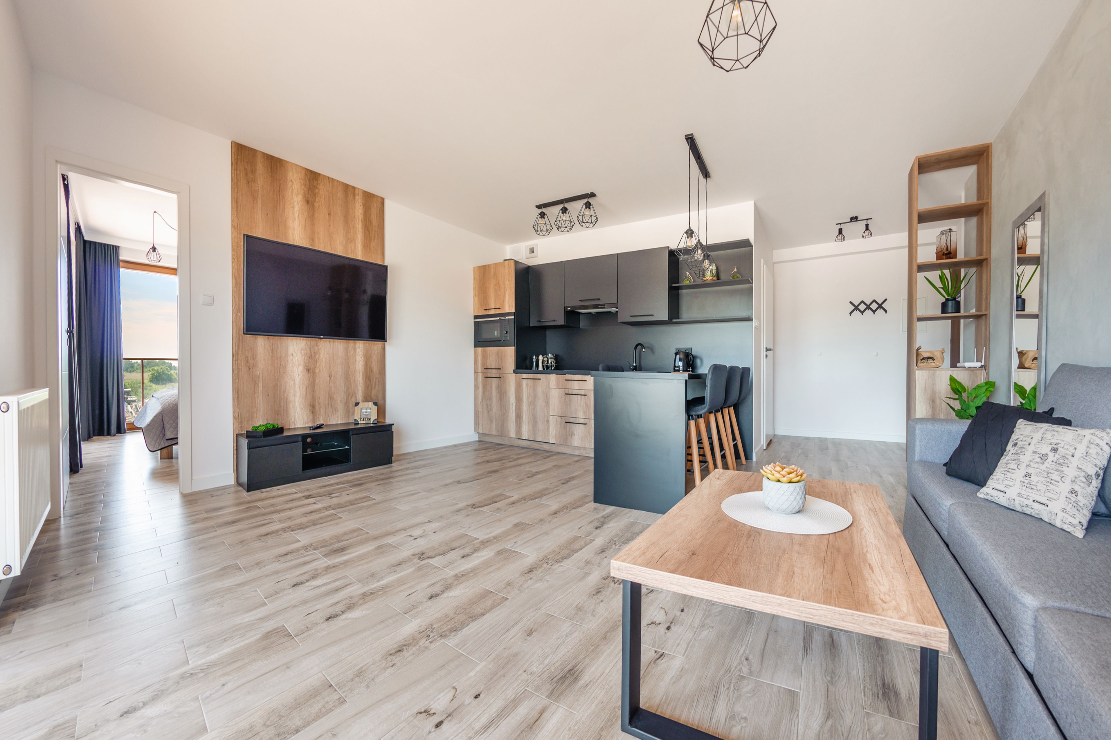 A modern apartment with a kitchen, dining area, and living room.