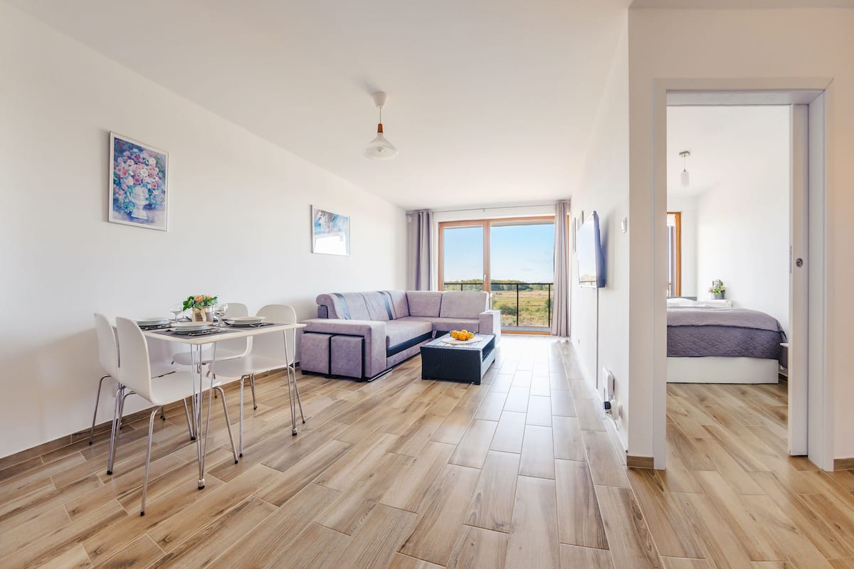 Ein modernes Wohnzimmer mit Essbereich, einer Couch und einem Bett.
