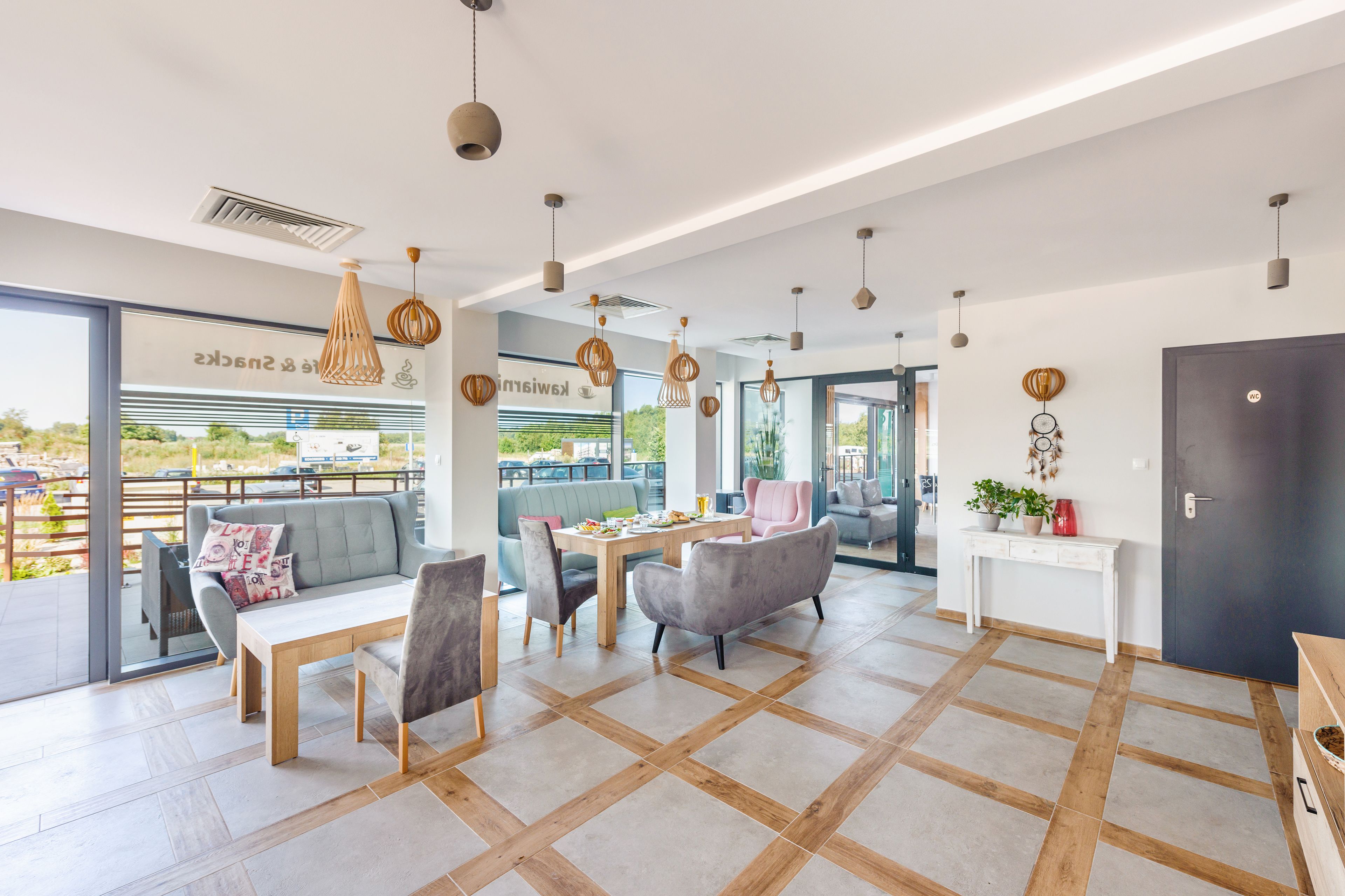 A modern interior with a dining area, sofas, and a view of the outdoors.