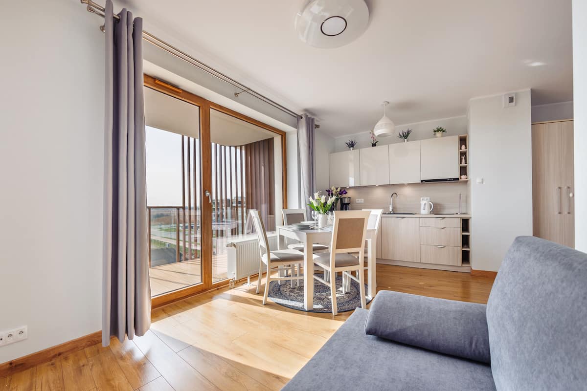 Eine moderne Wohnung mit Essbereich, Küche und einem Balkon mit Blick.