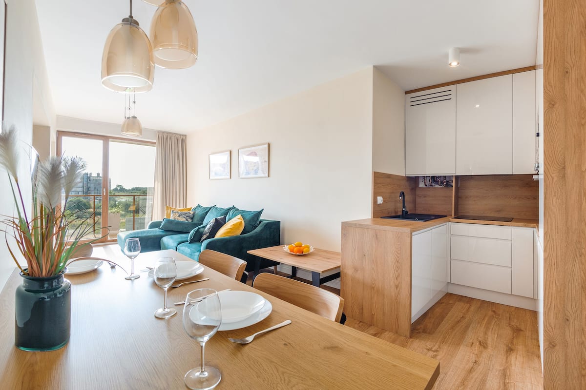 A modern apartment with a dining area, kitchen, and living space.