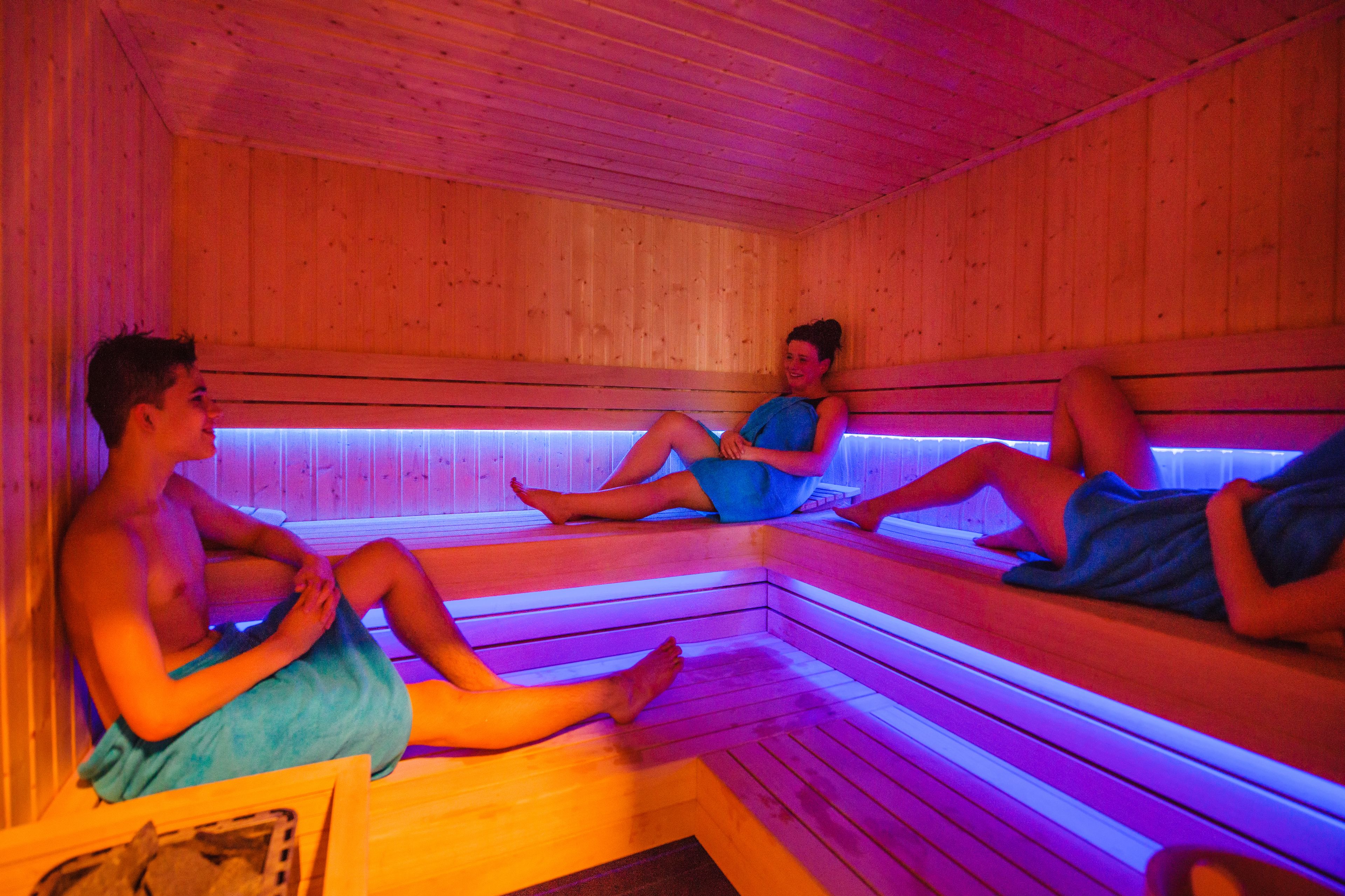Una sauna con bancos de madera y suelo de baldosas.