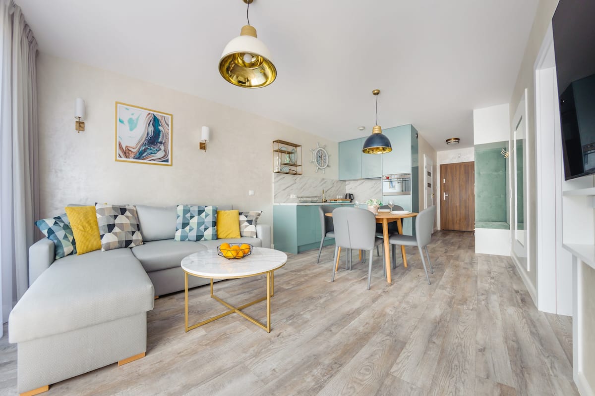 Ein modernes Wohnzimmer mit Sofa, Couchtisch und Essbereich.