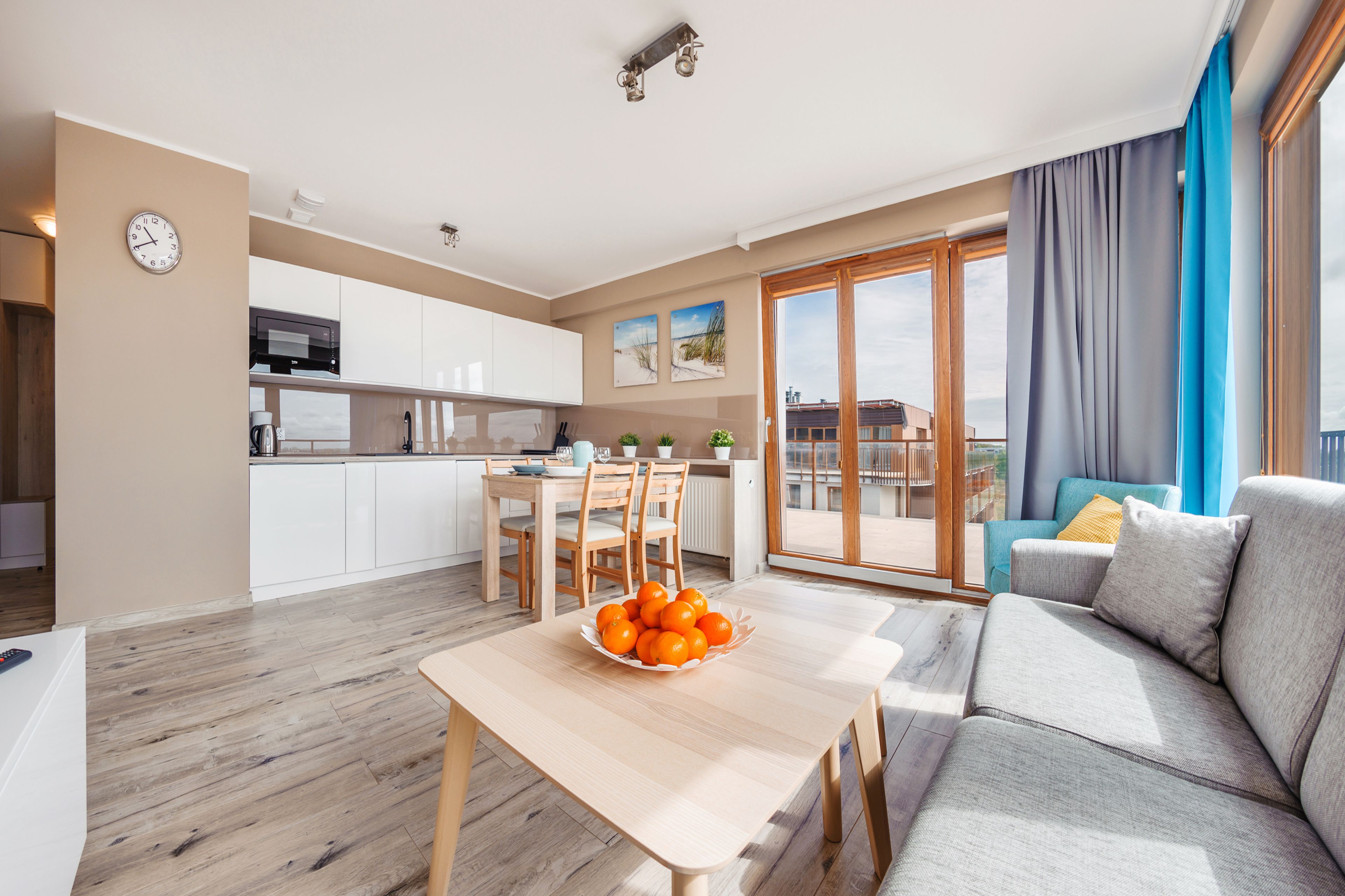 Eine moderne Wohnung mit Essbereich, einer Couch und einem Balkon mit Blick.