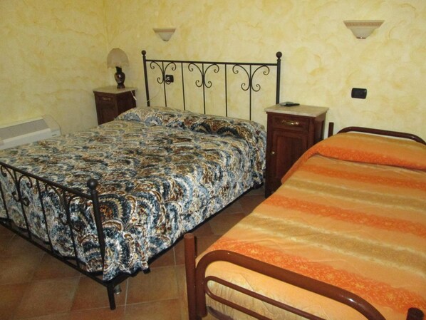 A bedroom with a bed, a nightstand, and a dresser. - Agriturismo Il Vecchio Carro (Campli)