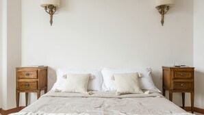 Ein Schlafzimmer mit einem großen Bett, zwei Nachttischen und Wandleuchten.