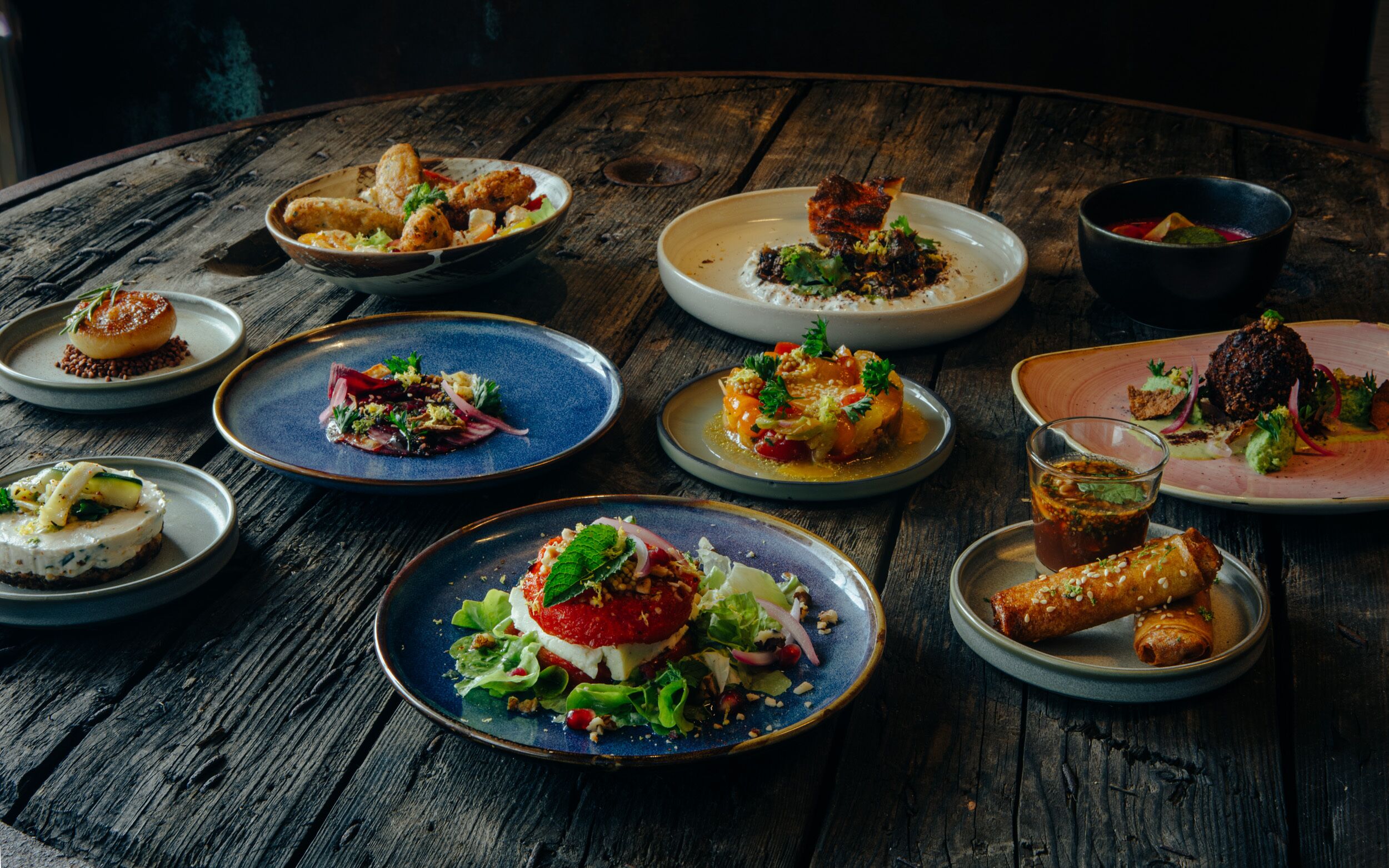 A variety of dishes on a rustic wooden table.