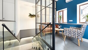 A modern interior with a staircase, a seating area with a table, and a window with a view of the outside. - Wine & Pillow Hotel by Frapolli (Odesa)