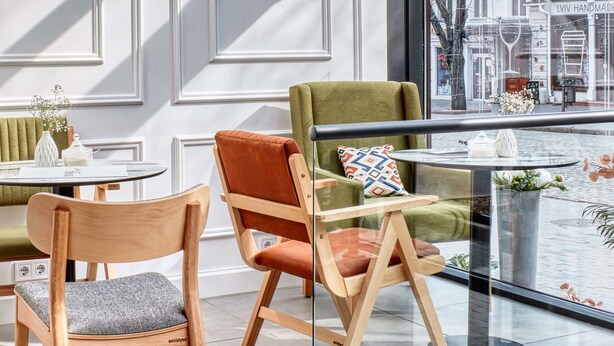 A modern interior with a glass railing, wooden chairs, and a view of the city. - Wine & Pillow Hotel by Frapolli (Odesa)