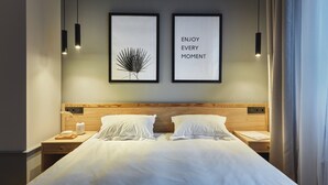 A neatly made double bed with white linens, two bedside tables with lamps, and two framed pictures on the wall. - Wine & Pillow Hotel by Frapolli (Odesa)