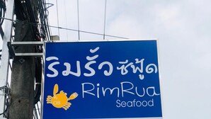 A sign for a seafood restaurant named RimRua, a resort and restaurant named Buena Villa, and a welcome open sign. - Bua Villa (Pathio)