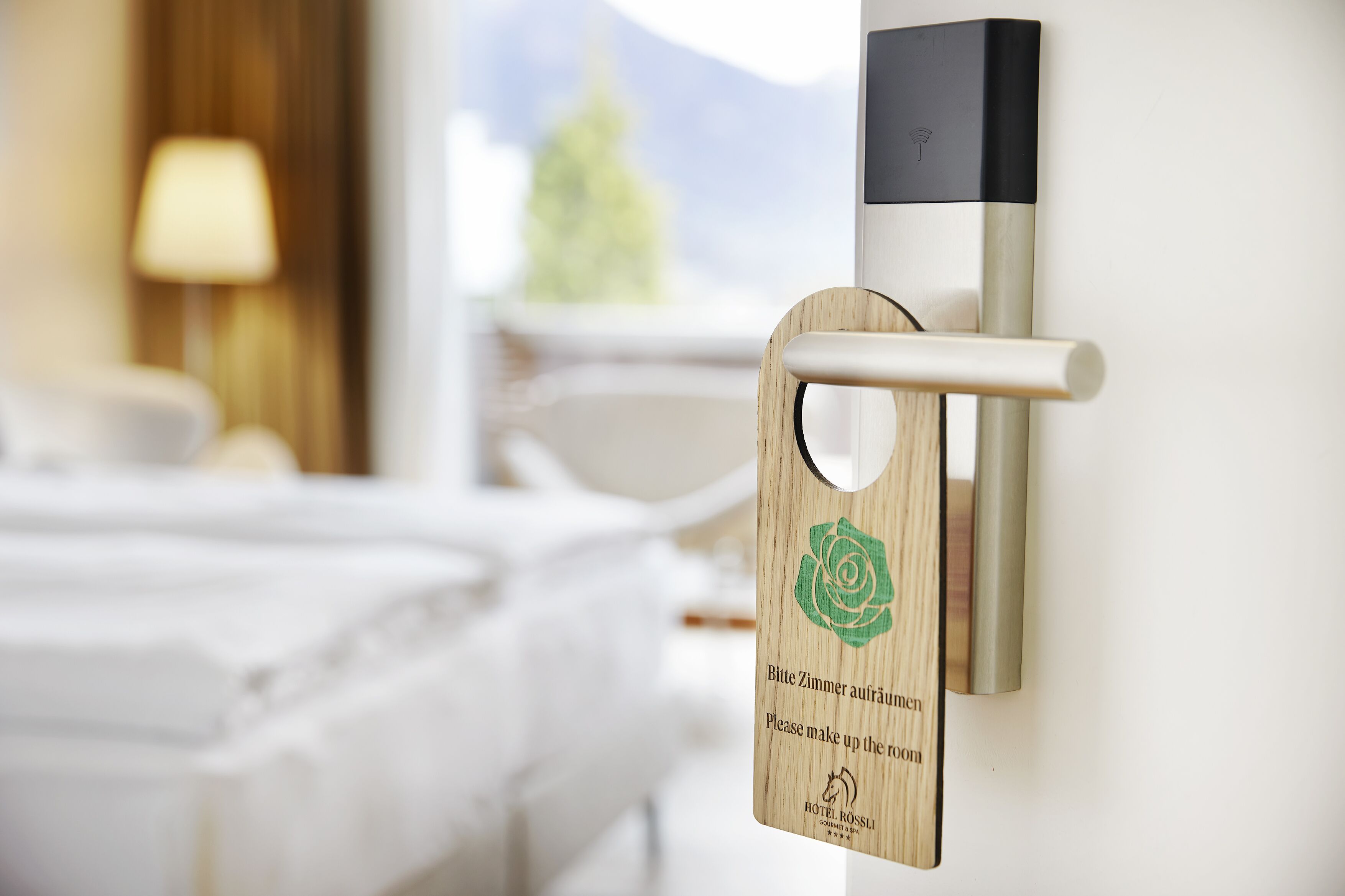 A hotel room door with a wooden sign requesting room service.