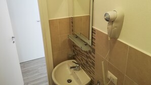 A bathroom with a sink, mirror, and hairdryer. - Leolù Guesthouse and breakfast (Alghero)