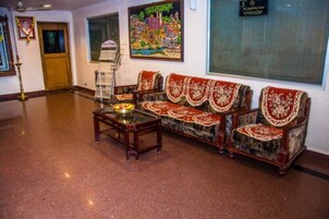 Una habitación tradicional con un conjunto de sofá, una mesita con un objeto decorativo y un cuadro en la pared.