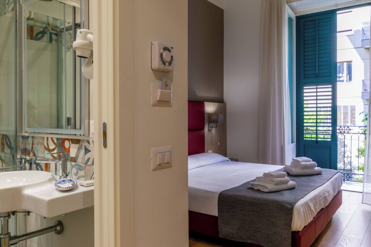Ett hotellrum med badrum, en säng och utsikt över omgivningarna.