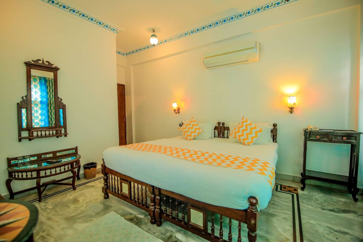 A bedroom with a wooden bed, a nightstand, a bench, and a wall-mounted air conditioner.