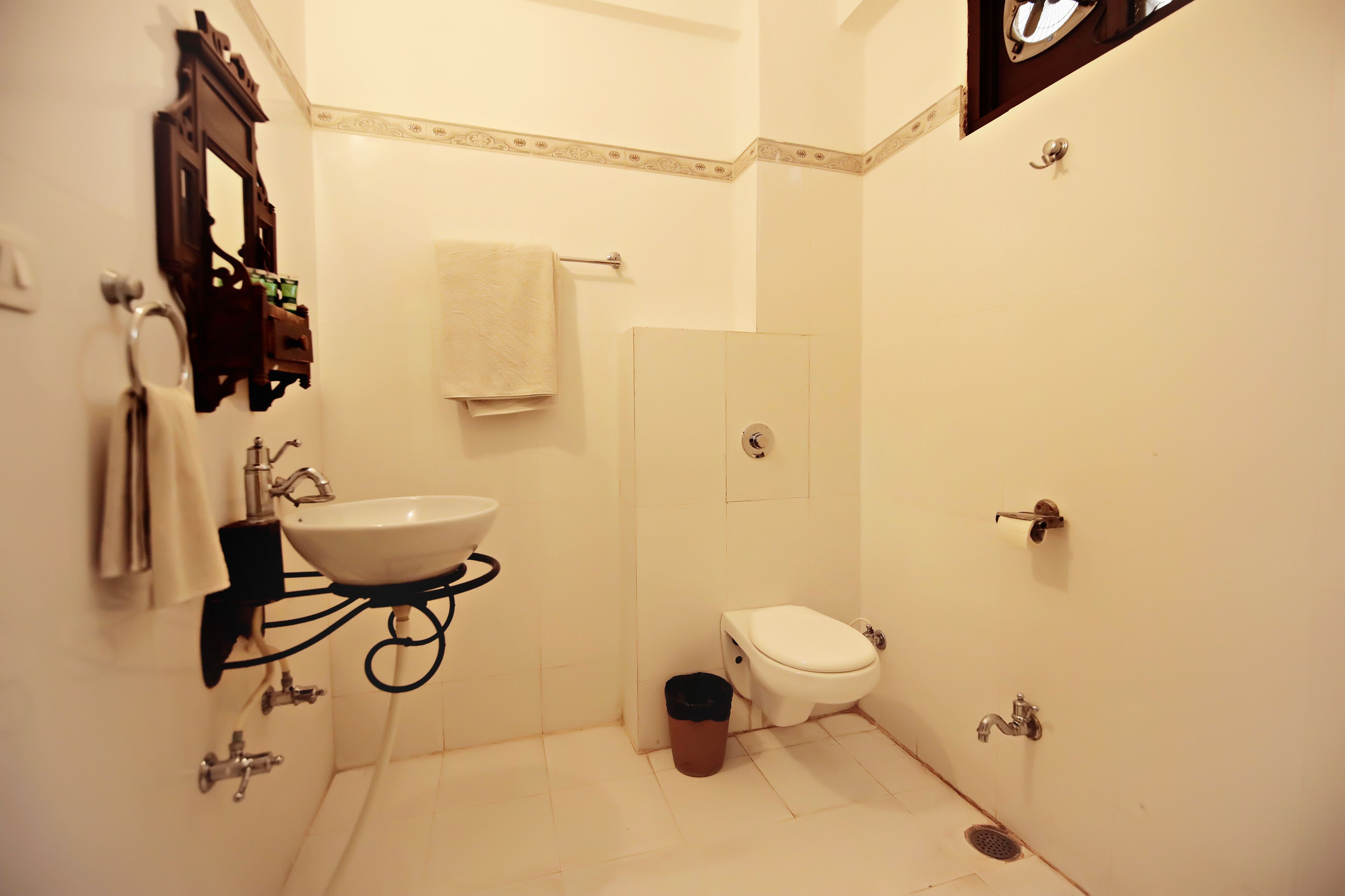 A small, clean bathroom with a white sink, toilet, and a mirror.