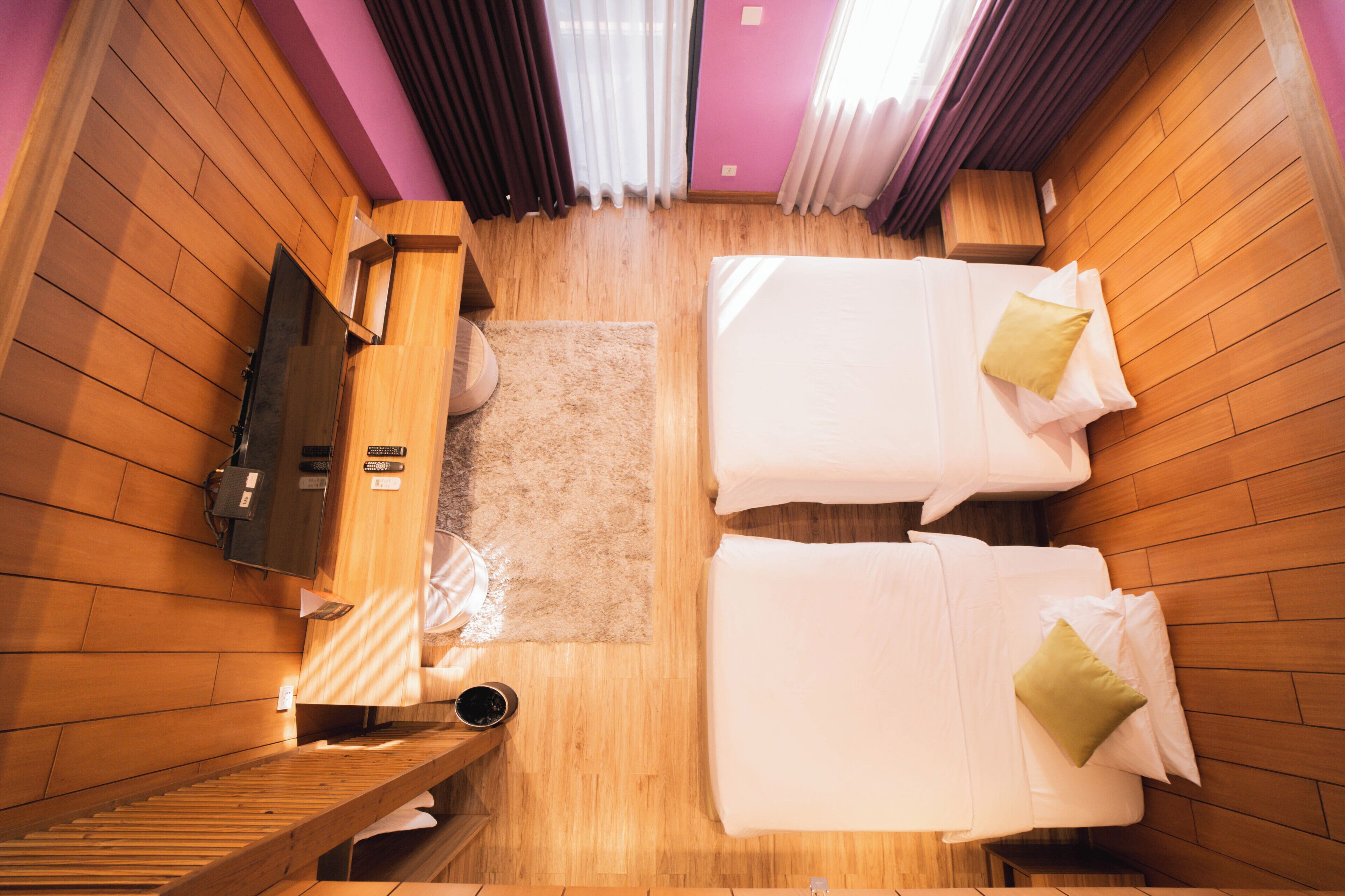 A room with two beds, a wooden bench, a small table, and a sauna area.